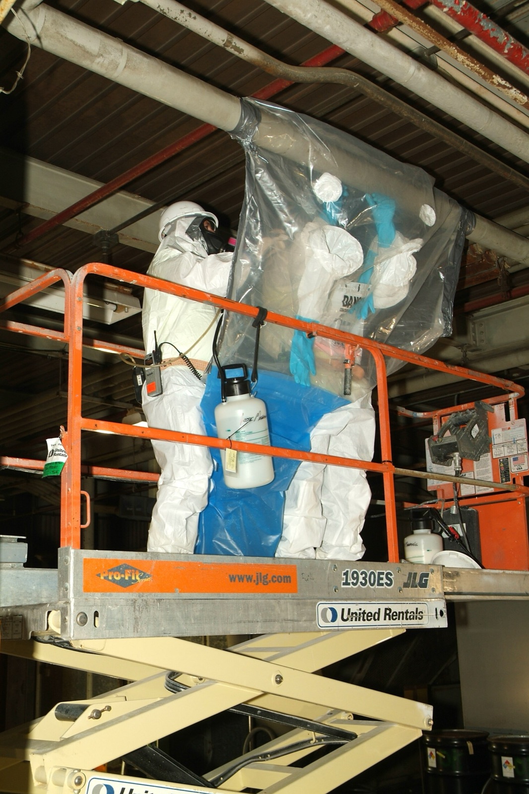 Federal workers performing asbestos removal inside an industrial facility