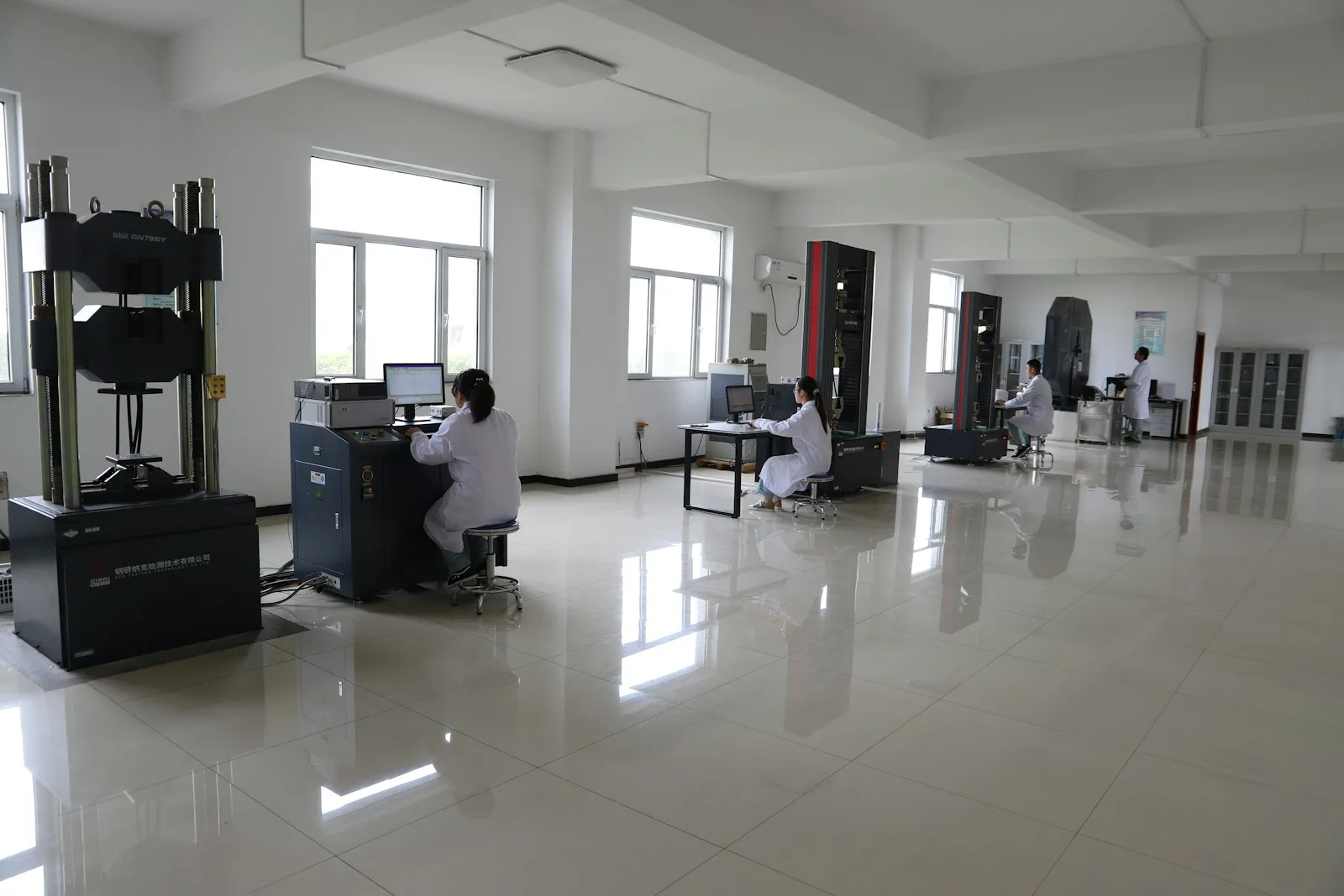 Laboratory technicians operating material-testing equipment